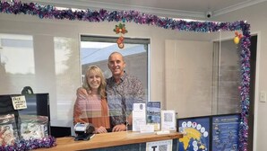 A reception desk with a sign for 'Face Masks' and a QR code for 'I NZ'. - ASURE Albert Park Motor Lodge (Te Awamutu)