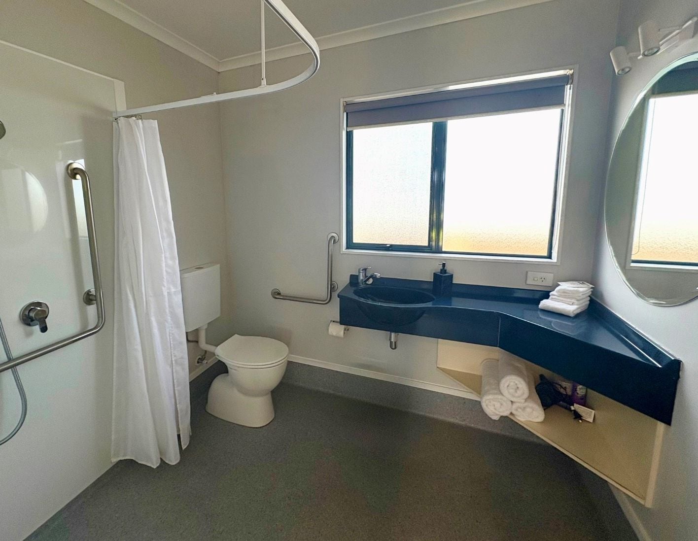 A modern bathroom with a shower, toilet, and sink.