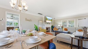 A modern living room with a dining area, a fireplace, and a television. - IMG Academy | Heated Pool, Game Room, Sleeps 10 (Bradenton)