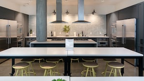 A modern kitchen with a large island, stainless steel appliances, and bar stools. - Cozy 1-bedroom apartment in SF with AC, fitness room (San Francisco)