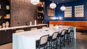 A modern kitchen with a marble island, dark wooden cabinets, and a seating area with a bench and chairs. - Cozy 1-bedroom apartment in SF with AC, fitness room (San Francisco)