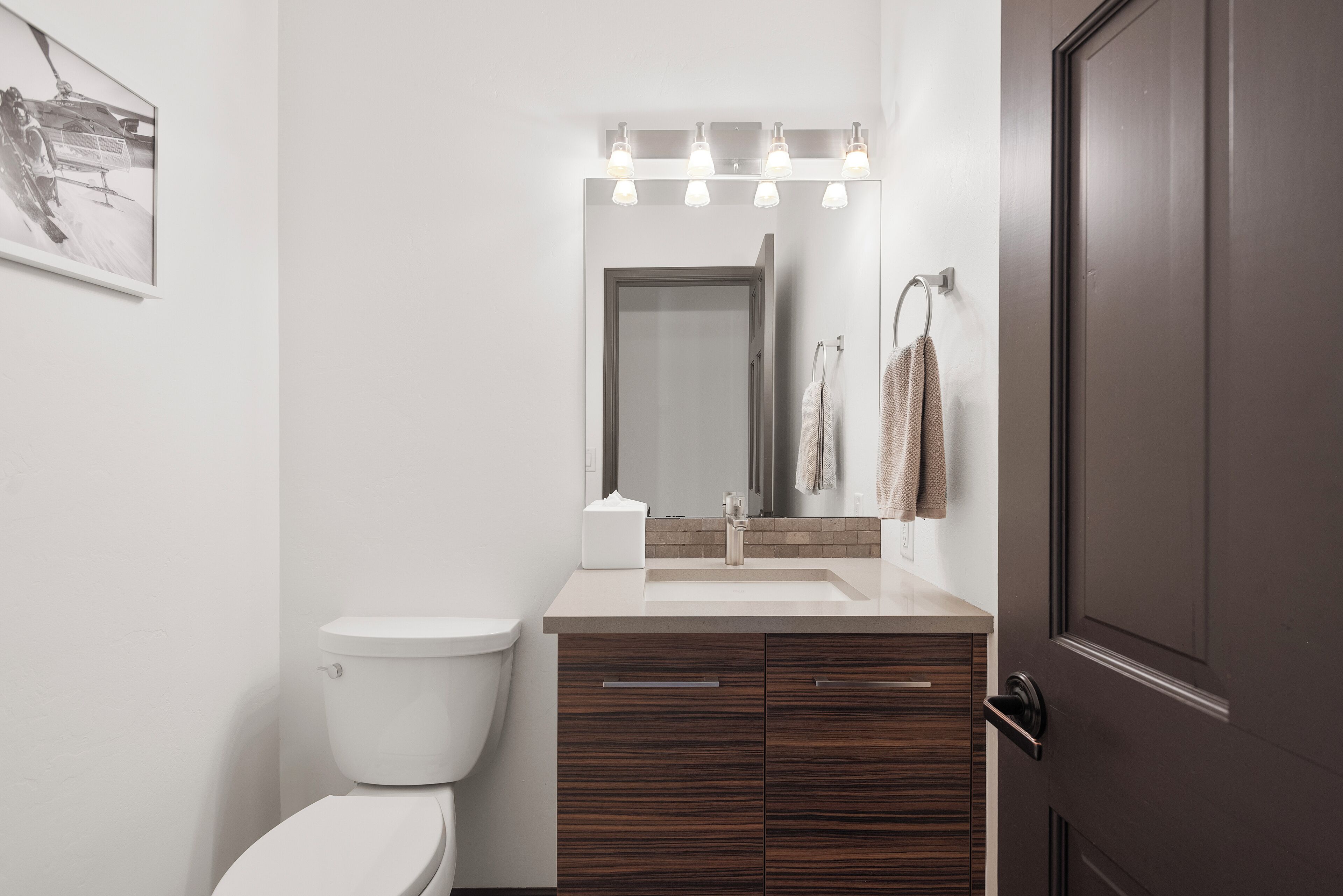 Ein modernes Badezimmer mit Toilette, Waschbecken und Spiegel.