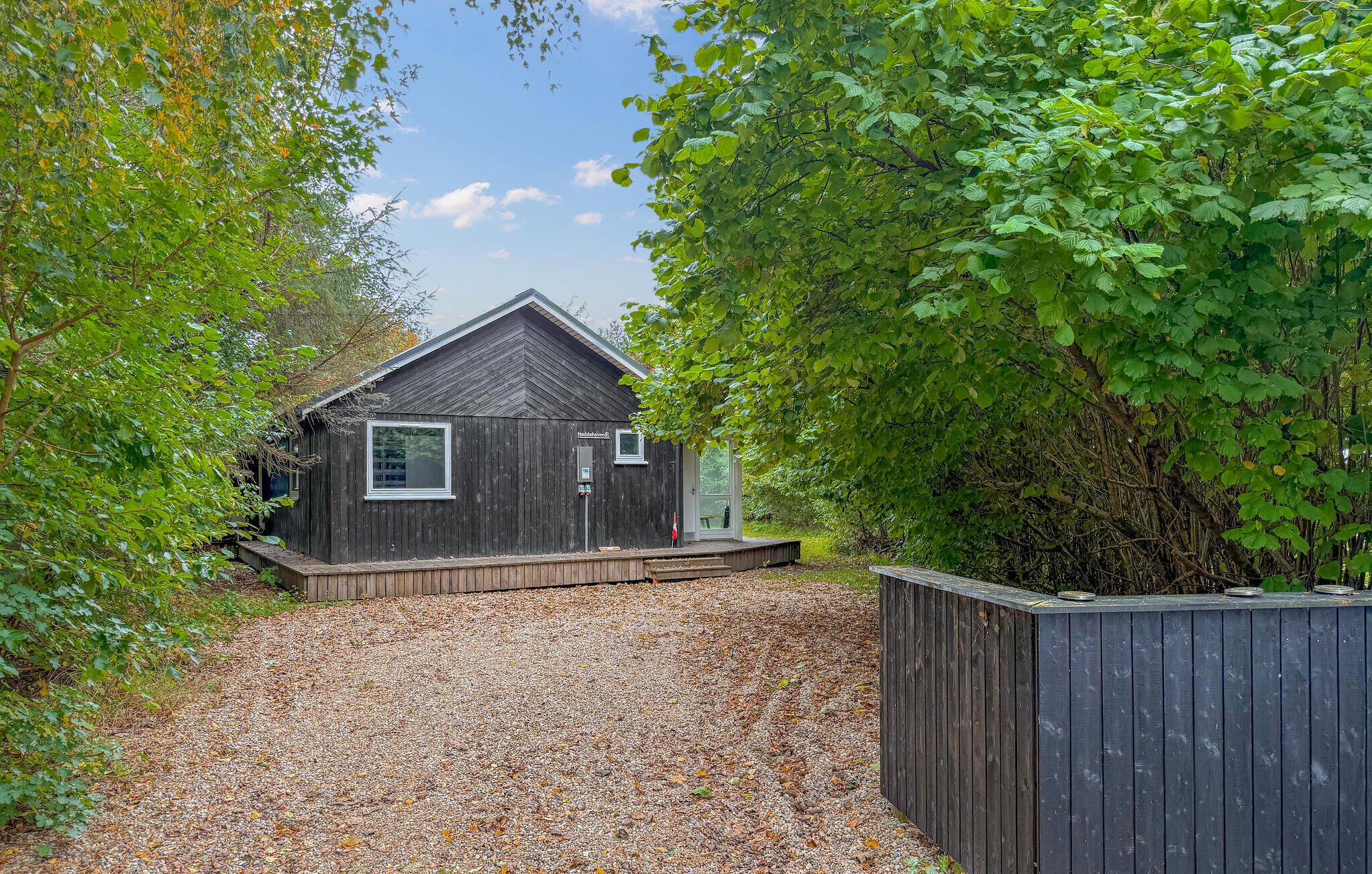 Een klein houten vakantiehuisje met een schuin dak, een raam en een deur.