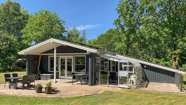 A modern house with a patio, a covered outdoor seating area, and a large window. - Stunning home in Ansager with WiFi (Ansager)