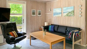 A living room with a leather chair, a wooden table, a black sofa, and a TV. - Stunning home in Ansager with WiFi (Ansager)