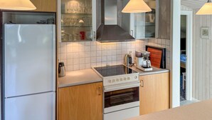 A compact kitchen with a refrigerator, stove, and coffee maker. - Stunning home in Ansager with WiFi (Ansager)