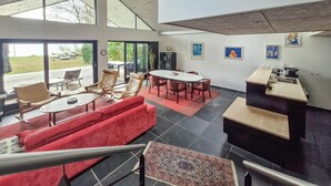 A spacious indoor area with a dining table, red sofas, and a kitchen area. - 3 bedroom stunning home in Sunds (Sunds)