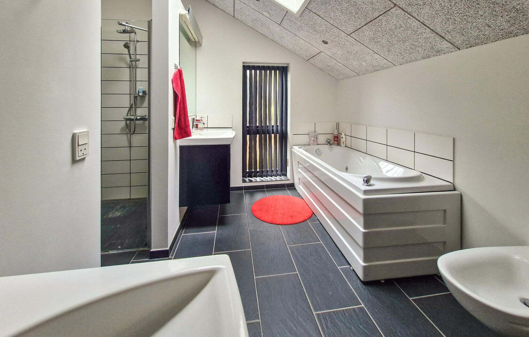 A modern bathroom with a bathtub, a sink, and a shower.