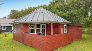 A red wooden structure with a sloped roof and a covered patio area. - Gorgeous home in Hovborg with WiFi (Hovborg)