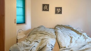 A single bed with a quilted blanket, a bedside table with a lamp, and a window with blinds. - Gorgeous home in Hovborg with WiFi (Hovborg)