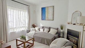 A modern living room with a sofa, a coffee table, and a fireplace. - Eclectic, Bright, & Spacious Retreat in the Heart of SLC (Salt Lake City)