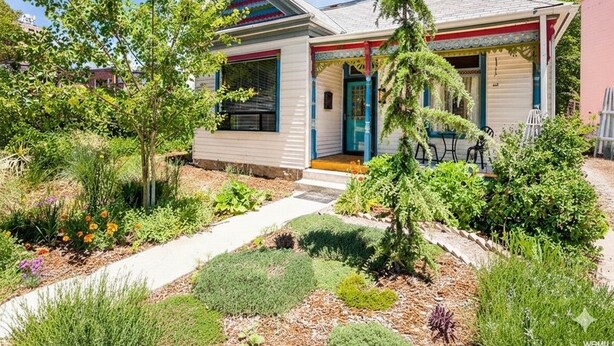 A house with a front porch, a small garden, and a pathway leading to the entrance. - Eclectic, Bright, & Spacious Retreat in the Heart of SLC (Salt Lake City)