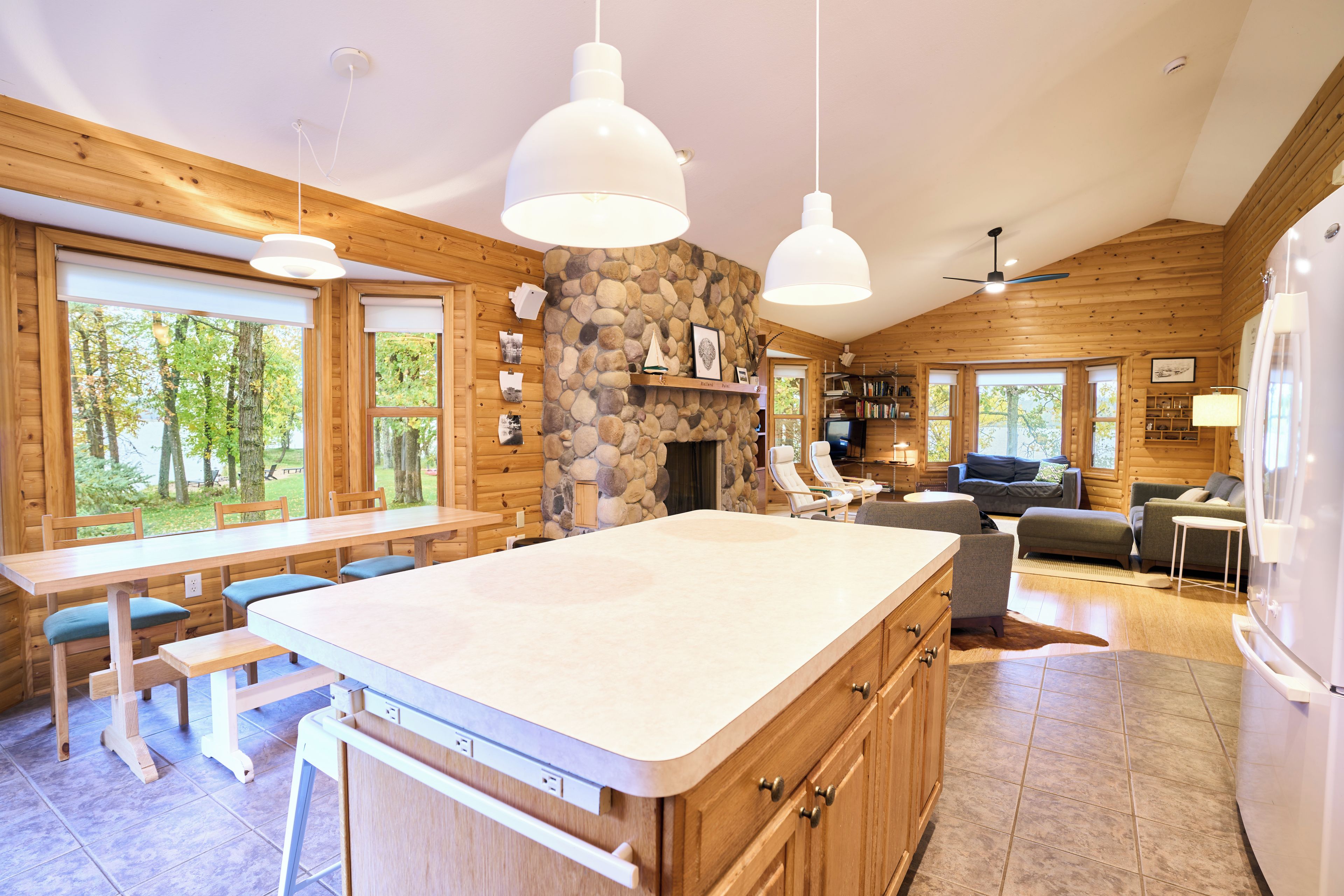 A spacious kitchen with a large island, wooden cabinetry, and a stone accent wall.