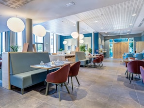 A modern restaurant with high ceilings, pendant lighting, and a mix of seating options including booths and tables. - Quality Aparthotel Morangis Orly (Morangis)