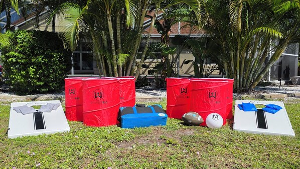 A grassy area with red trash bins labeled 'WickedBig' and a white table with a black stripe.