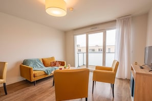 Appartement 1 chambre | Living area | 42-inch flat-screen TV with digital channels