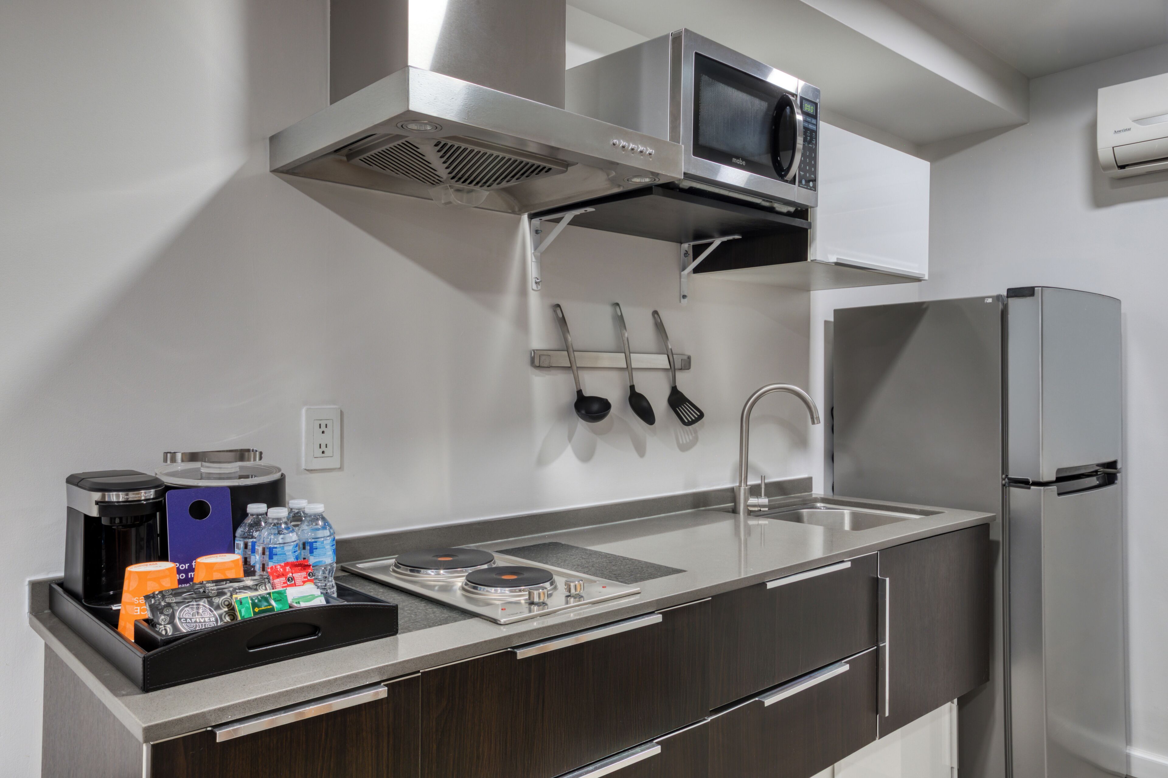 A modern kitchen with a stainless steel refrigerator, microwave, and stove.