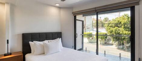 A bedroom with a bed, bedside table, and a ceiling fan.