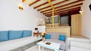 A modern living room with a sofa, a coffee table, and a staircase leading to a kitchen. - LiRi - Family paradise (Ialysos)