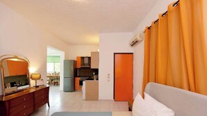 A hotel room with a bed, a desk, a chair, a kitchenette, and a bathroom. - Dani's House (Ialysos)