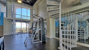 A gym with weightlifting equipment, a large window, and a spiral staircase. - Lake Views, Resort Pools & Near the Beach | Laketown Wharf 114 (Panama City)