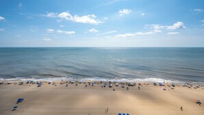 Una spiaggia con ombrelloni e persone.