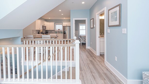 A spacious kitchen with modern appliances, a dining area, and a staircase leading to an upper level.