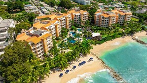 An aerial view of a resort with multiple buildings, a beach, and a swimming pool. - Saint Peter's Bay 208 - Chic Beachfront Condo (Battaleys)