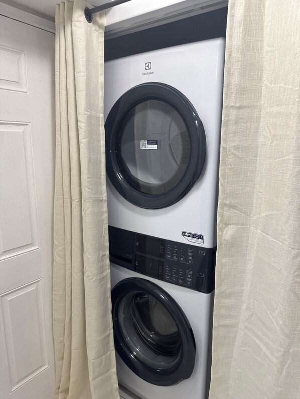 A front-loading washing machine with a control panel and a dryer below it.