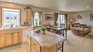 A spacious kitchen with wooden cabinets, a central island, and a dining area with a table and chairs. - Paradise Found Condo with Stunning Mountain Views located in Paradise Valley, MT (Emigrant)