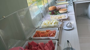 A buffet with various food items and a kitchen area with a stove. - HOTEL XIQUE XIQUE POUSADA (Piranhas)