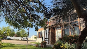 A hotel with a wooden facade, large windows, and a well-maintained lawn. - HOTEL XIQUE XIQUE POUSADA (Piranhas)