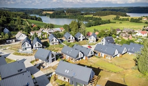 Un quartier résidentiel avec des maisons modernes, un lac et une végétation luxuriante.