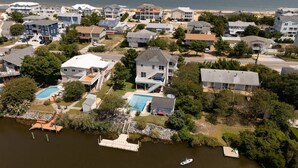 A residential area with houses, a swimming pool, and a dock with a boat.