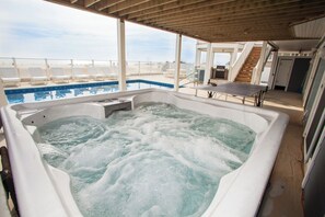 A hot tub with a view of the beach, a pool, and a table tennis table. - Bellissimo - Oceanfront with Pool, Hot Tub, Theater Room, Elevator, Game Tables (Virginia Beach)