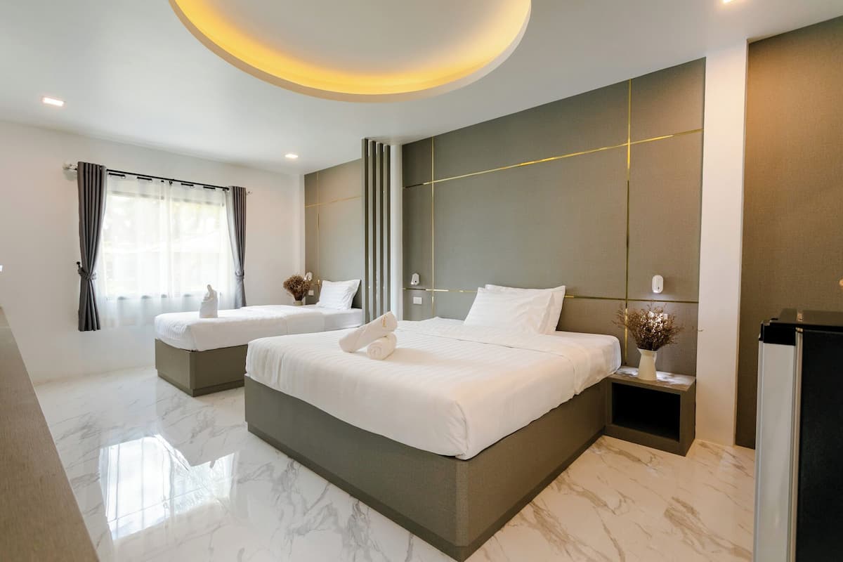 A modern hotel room with a large bed, two smaller beds, a marble floor, and a ceiling light fixture.