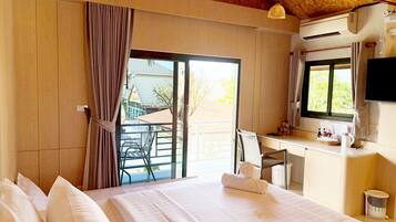 A hotel room with a bed, a desk, a chair, a TV, and a window with curtains.