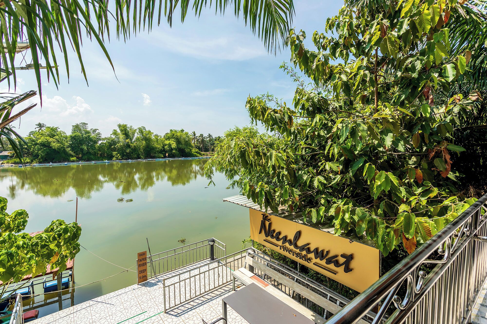 A riverside view with a sign for 'Nekton Riverside'.