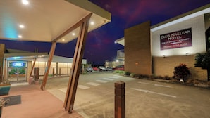 The Club Maclean Motel entrance with a parking area and a building with a signboard. - Club Maclean Motel (Maclean)