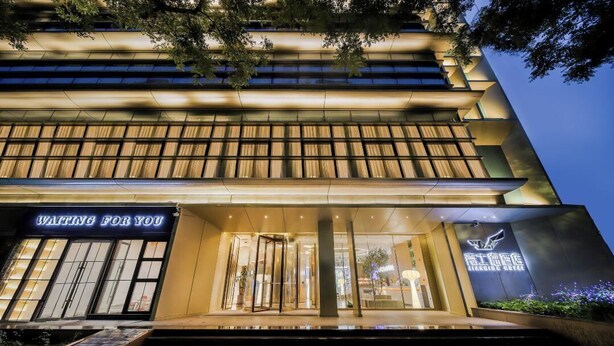 A hotel entrance with a revolving door, a sign reading "WAITING FOR YOU," and a logo with Chinese characters. - BEIJING JIASHIDE HOTEL (Tongzhou)