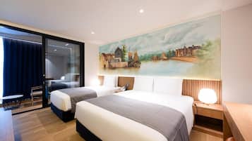 A hotel room with two beds, a painting of a riverside scene, a desk, and a chair.