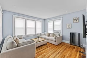 A living room with two sofas, a coffee table, and a radiator.