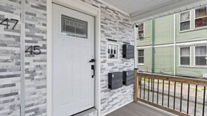 A building with a white door, numbered 47 and 45, and a green exterior. - Roger William 2nd Floor- 3 Bedroom apartment ALL included- Long Term (Providence)