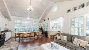 Amplia sala de estar con una mesa de comedor, un sofá y una cocina al fondo.