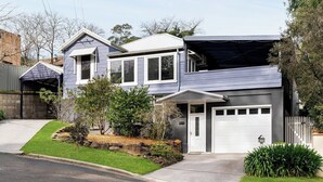 A two-story house with a garage, a driveway, and a well-maintained lawn.