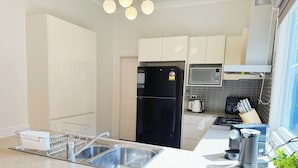 A modern kitchen with stainless steel appliances, a microwave, and a gas stove.