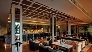 A spacious lounge area with a bar, seating arrangements, and a view of the bar area. - METT Singapore (Singapore)