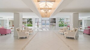 Un'ampia hall con soffitto alto, grandi finestre e un lampadario centrale.