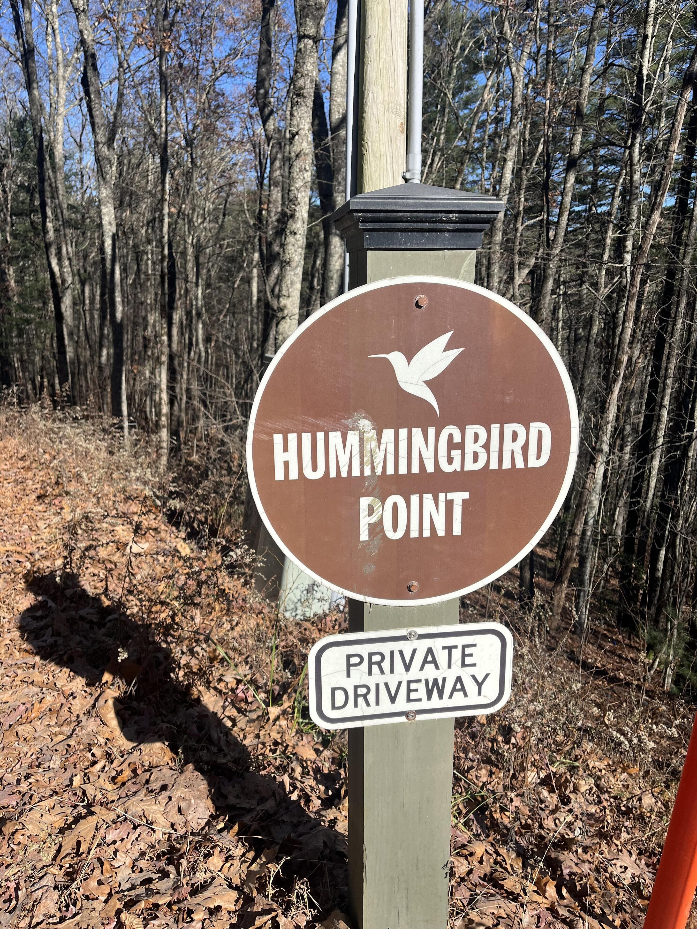 A sign indicating a hummingbird point and a private driveway.