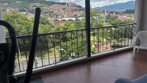 A balcony with a view of a cityscape, including buildings and greenery. - Vista Hermosa Apartment In The Middle Of Medellin (Medellín)